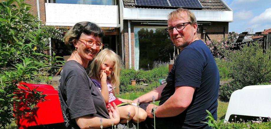 Melanie und Oliver Böhme mit einer Tochter vor ihrem Haus