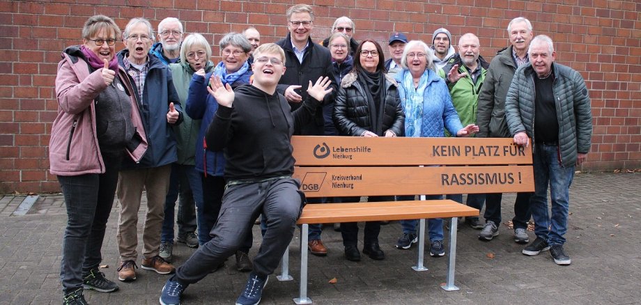 Eine Gruppe von Menschen aus Rehburg-Loccum macht vor einer Bank deutlich, dass dort kein Platz für Rassismus ist