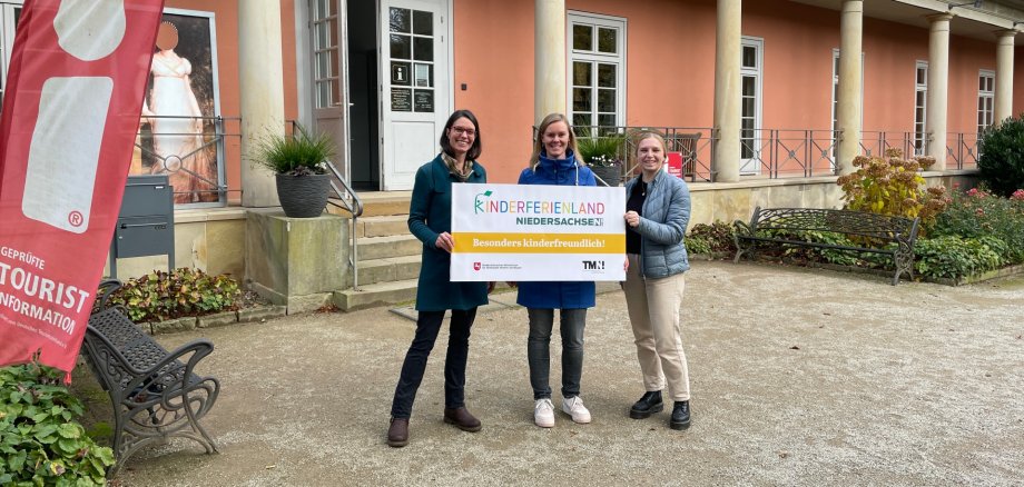 Gesa Polster, Gretje Bode und Marie Witte mit dem Kinderferienland-Banner vor der Romantik Bad Rehburg