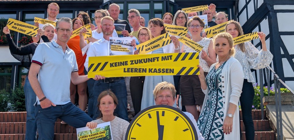 Mitarbeitende des Rathauses stellen sich demonstrativ vor dem Haupteingang auf, um auf die Unterfinanzierung der Kommunen hinzuweisen