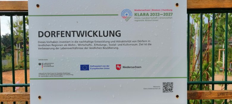 Hinweisschild auf das Förderprogramm Dorferneuerung