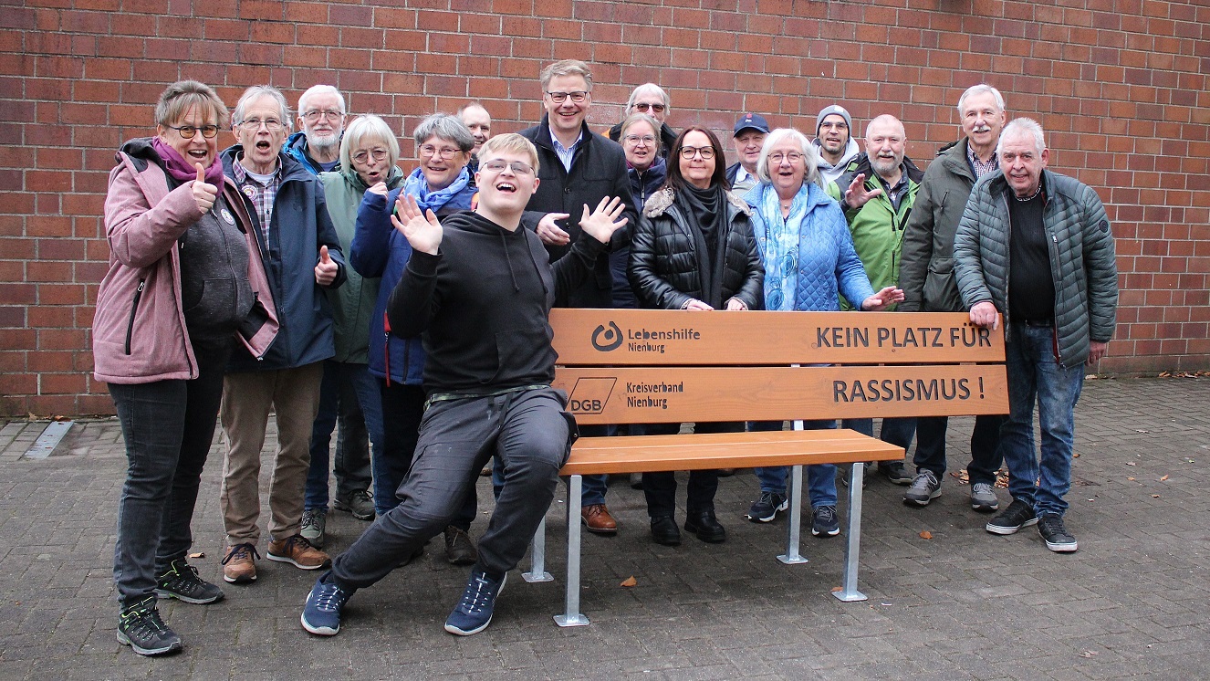 Eine Gruppe von Menschen aus Rehburg-Loccum macht vor einer Bank deutlich, dass dort kein Platz für Rassismus ist