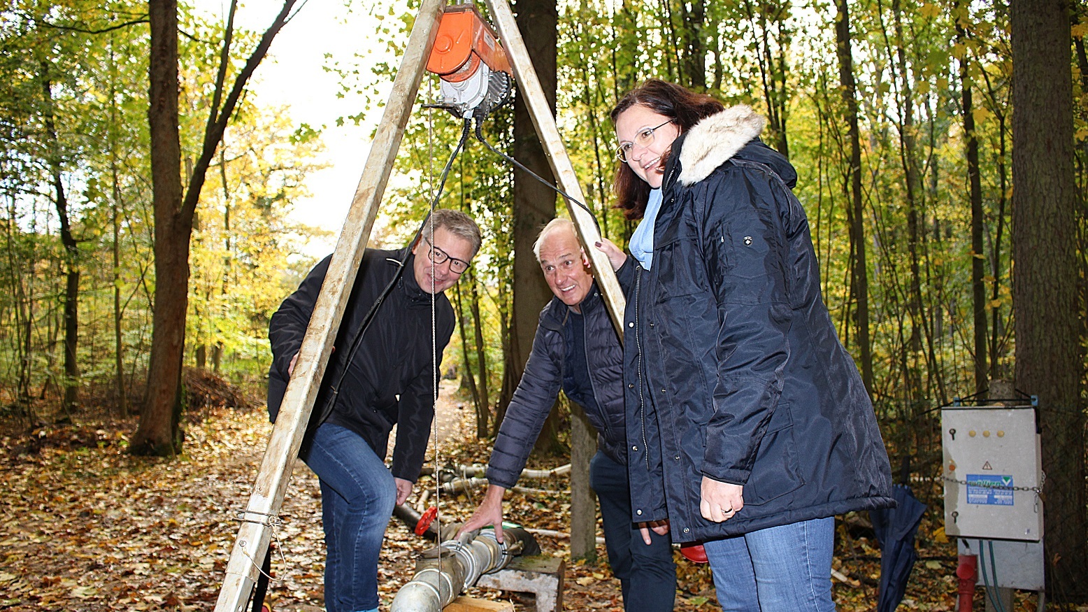 Martin Franke, Dirk Fennekoldt und Michaela Klein beugen sich über den Brunnenschacht