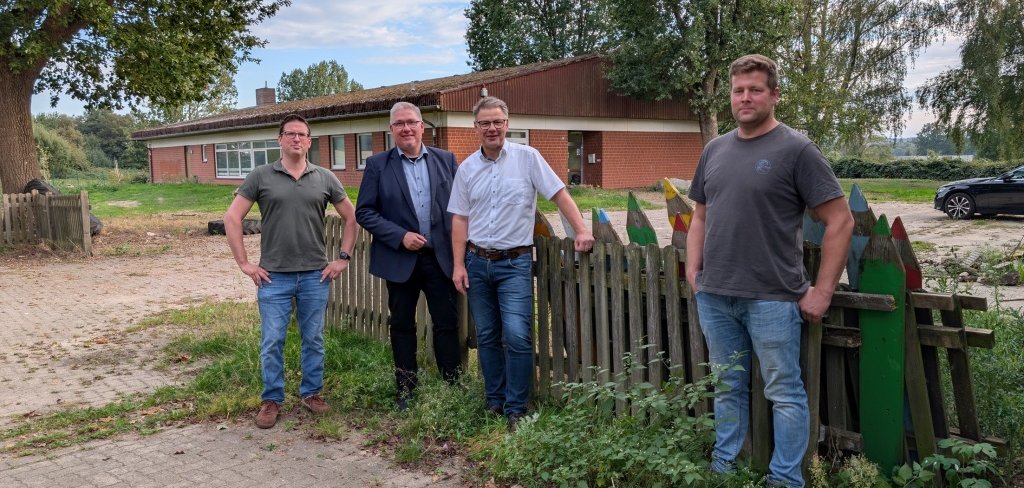 Marc Jaschke und Kai Hauser (beide DLRG, von links) sowie Jan Witte (DLRG, rechts) mit Bürgermeister Martin Franke vor dem künftigen DLRG-Zentrum 