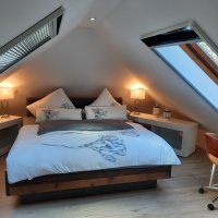 Ferienhaus Max Schlafzimmer mit doppelbett und zwei Dachfenstern