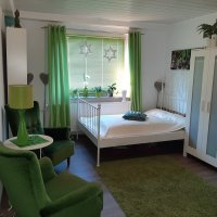 Schlafzimmer mit Bett, Schrank und Sitzmöglichkeit