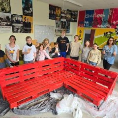 Jugendliche des JUZ stehen hinter ihrem selbstgebauten Palettensofa