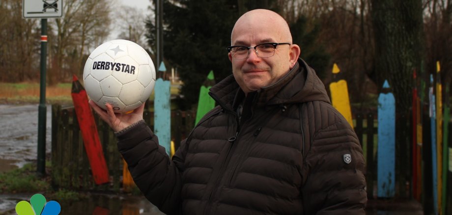 Carsten Schmidt mit einem symbolischen Fußball in der Hand