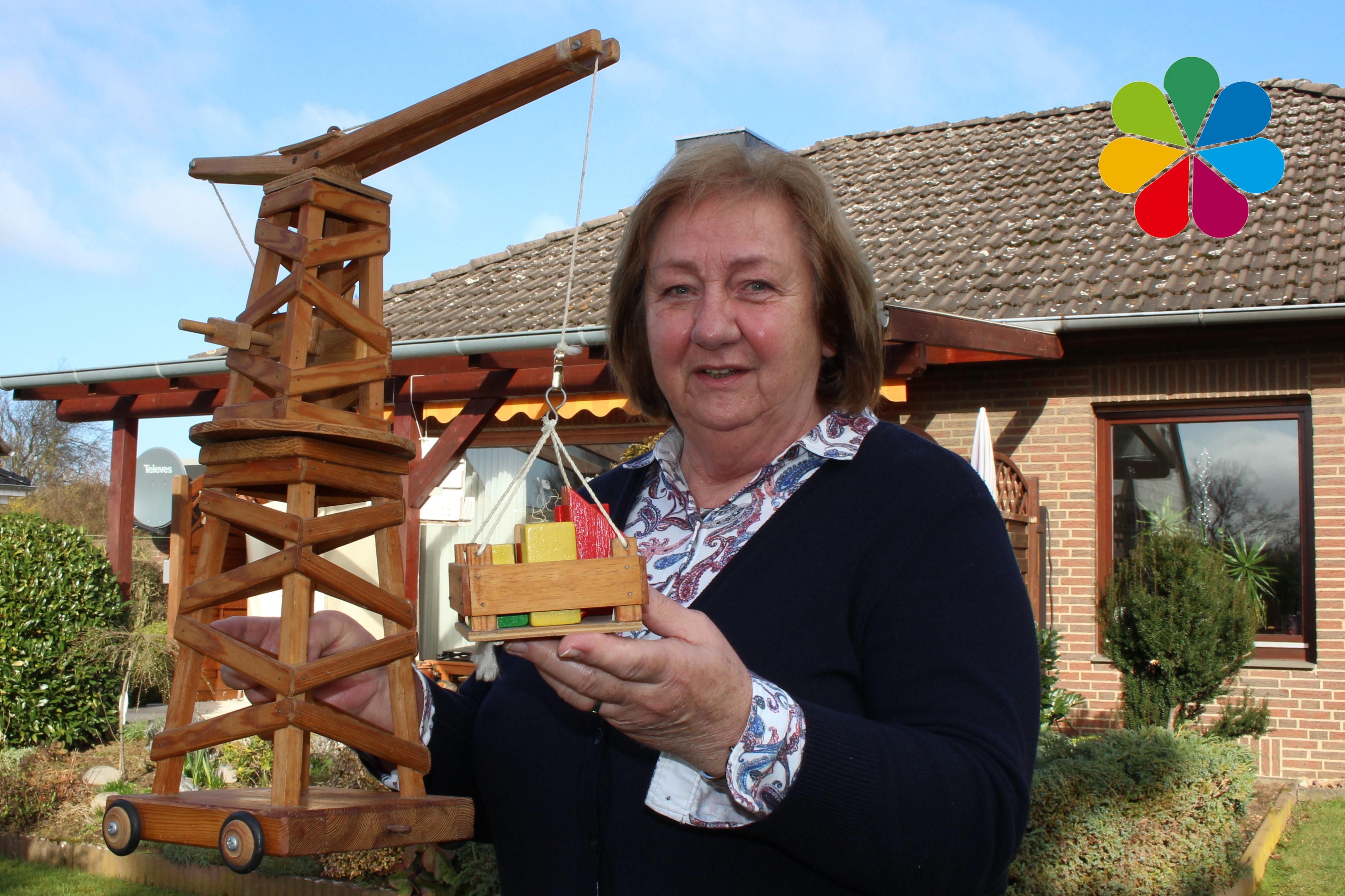 Dörte Zieseniß mit einem Holzkran in ihrem Garten