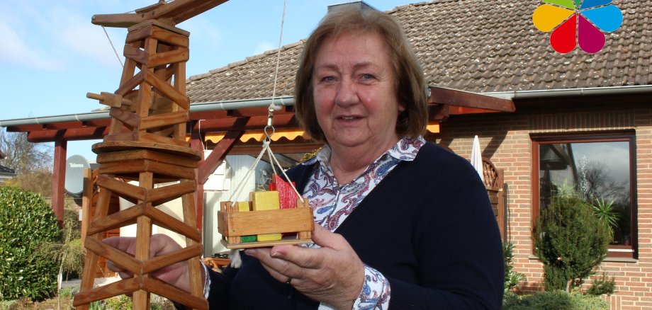 Dörte Zieseniß mit einem Holzkran in ihrem Garten