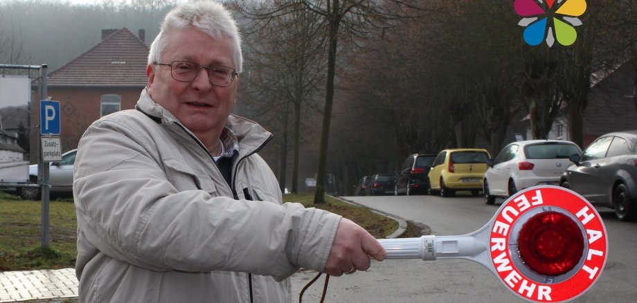 Jürgen Wagner mit einer Winkerkelle der Freiwilligen Feuerwehr in der Hand