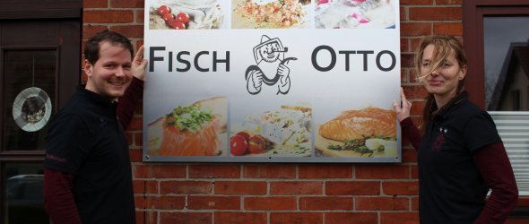 Inhaber von Fisch Otto vor ihrem Schild