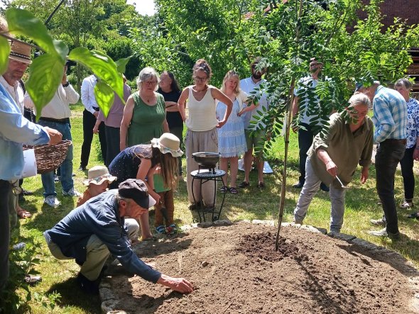 Ein Beet, der Baum und Gäste, die während der Trauerfeier Blumenzwiebeln setzen: Die endgültige Bestattung von Herbert Grill ist zu einem Fest geworden. privat Ein Beet, der Baum und Gäste, die während der Trauerfeier Blumenzwiebeln setzen: Die endgültige Bestattung von Herbert Grill ist zu einem Fest geworden. privat